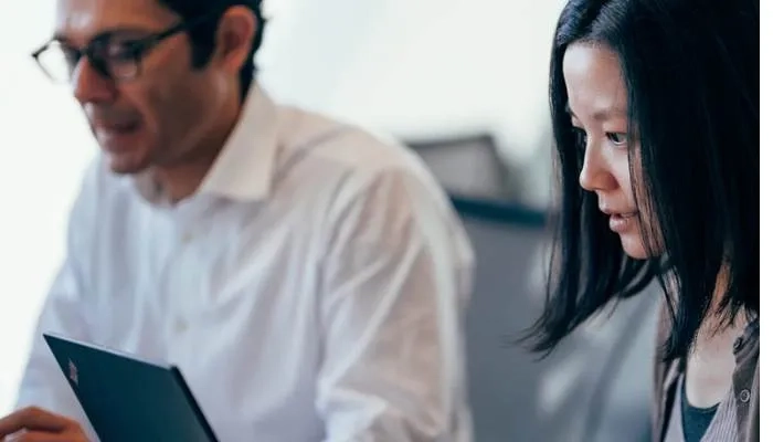 Two people working at laptop